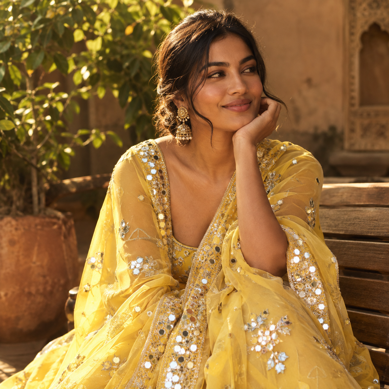 Woman smiling in a yellow embroidered mirror work drape